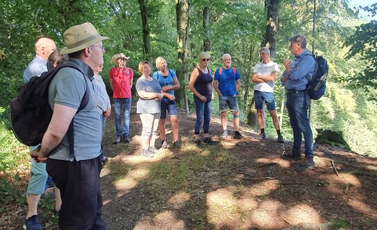 Eine kleine Gruppe steht im Wald, bereit zu wandern
